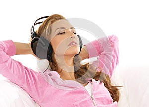 A young woman listening to the music in headphones