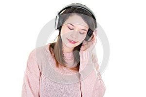 Young woman listening to music on headphones with closed eyes looking down