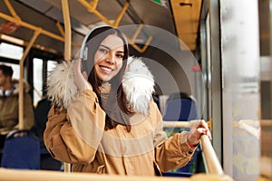 Young woman listening to music with headphones in public transport