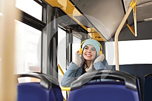 Young woman listening to music with headphones in transport