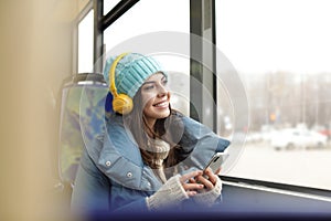 Young woman listening to music with headphones in transport