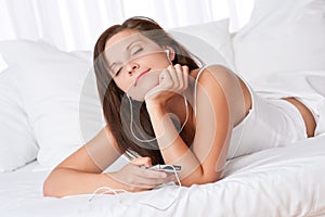 Young woman listening to music holding mp3 player