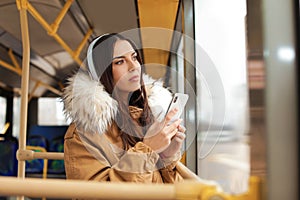 Young woman listening to music in public transport