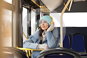 Young woman listening to music in public transport