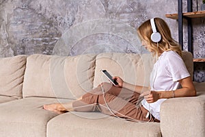 Young woman listening to music while relaxing on sofa at home