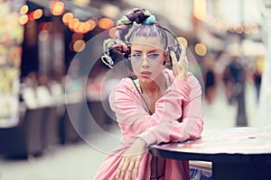 Young woman listening to music via headphones on the street - Hipster Girl with a nonconformist fashion look