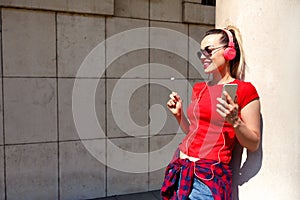 Young woman listening to music via headphones on the street