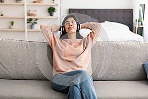 Young woman listening to music wearing headphones