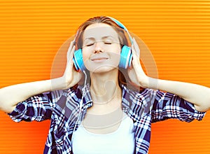 Young woman listens and enjoys the good music in headphones