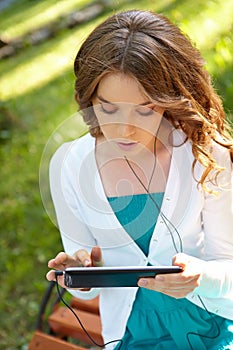 Young woman listens music using tablet pc.