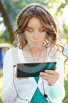 Young woman listens music using tablet pc.