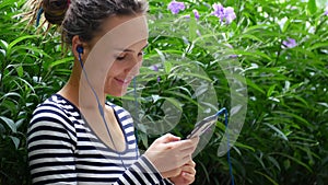 A young woman listens to music and communicates with friends on the Internet.