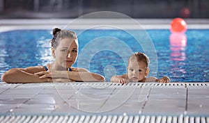 Young woman and little son resting poolside