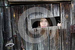 A young woman locked in a wooden old barn.