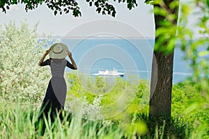 Young woman in a long dark blue skirt on the waterfront near the