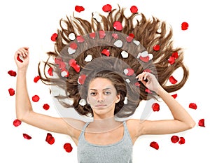 Young woman with long hairs and rose petals