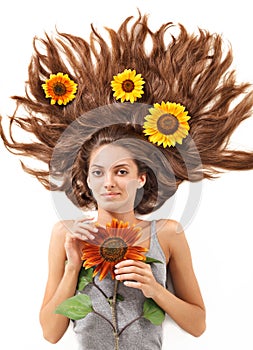 Young woman with long hairs and sunflower