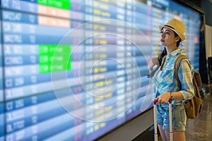 Young woman look at flight timetable worries