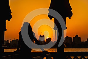 Young woman looking at the astonishing sunset on the Nile river from a boat in Cairo, Africa