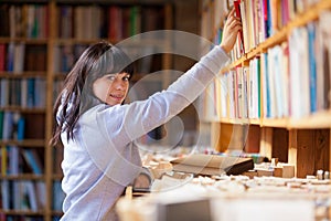 Young Woman Looking At Books In A Bookstore