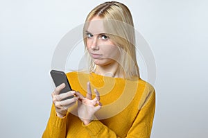 Young Woman Looking at the camera with her Mobile Phone