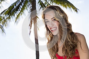 Young woman looking at the camera, palm tree