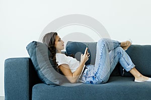 Young woman looking at cellphone screen, reading message with amazing news, having fun watching photo or video content online in