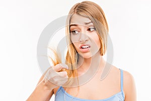 Young woman looking at damaged split ends