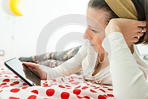 Young woman looking on digital tablet or e-book device