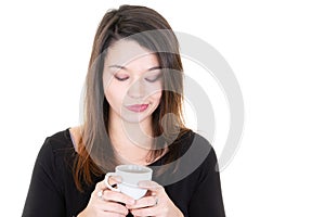 Young woman looking down coffee cup in hand