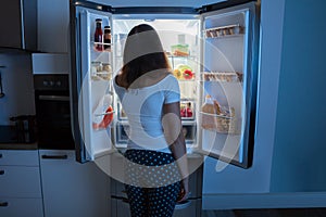 Young Woman Looking In Fridge