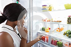 Young Woman Looking In Fridge photo