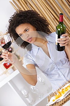 Young woman looking at glass red wine