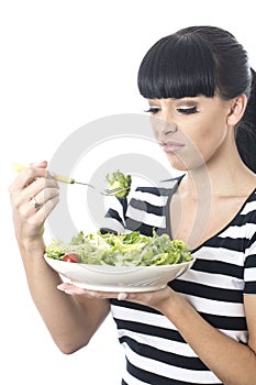 Young Woman Looking at Healthy Bowl of Green Salad Leaves with distaste