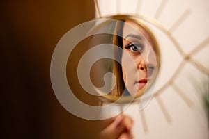 Young Woman Looking At Her Reflection In Beauty Clinic