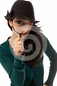 Young woman looking through magnifying glass