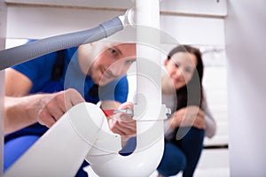 Male Plumber Fixing Sink Pipe photo