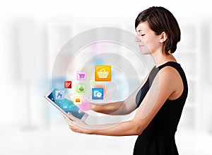 Young woman looking at modern tablet with colourful icons