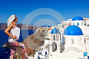 Young woman looking at Oia in Santorini, Greece