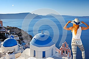 Young woman looking at Oia in Santorini, Greece