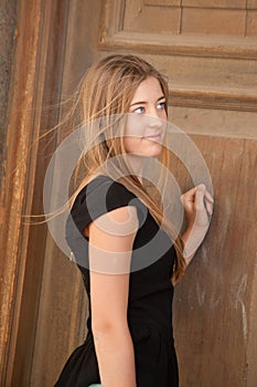 Young woman looking at an old door