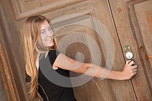 Young woman looking at an old door