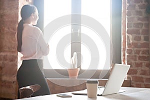 Young woman looking out window in office