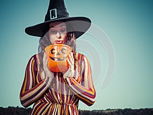 Young woman looking in plastic pumpkin