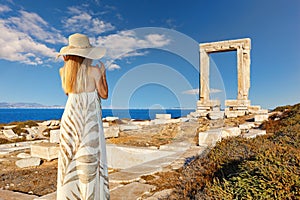 Young woman looking at Portara in Chora of Naxos island, Greece