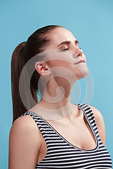 The young woman is looking satisfy on the blue background.