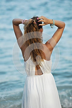 Young woman looking at sea water in summer holiday taking ponytail on her hair enjoying vacation relaxed