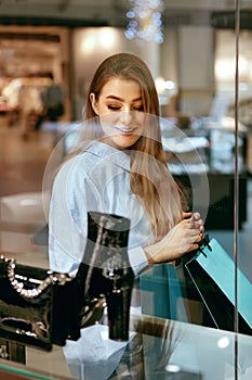 Young Woman Looking Through Shop Window