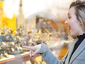 Young woman looking at a shop window jewellery