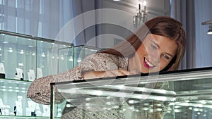 Young woman looking in the showcase at the jewelry store